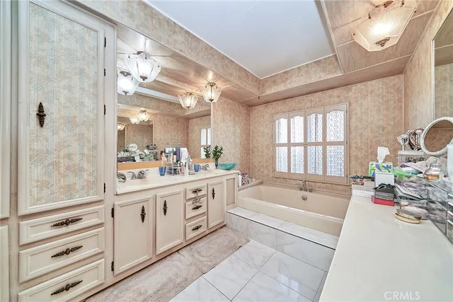 a spacious bathroom with a tub sink and mirror