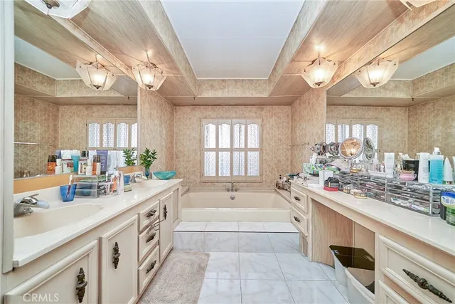 a large white kitchen with a large window and sink