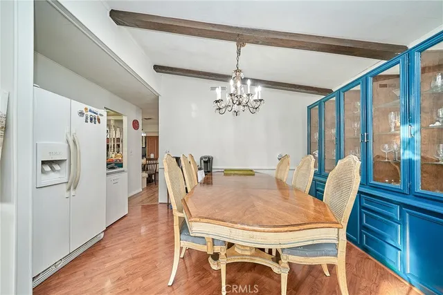 a dining room with furniture a chandelier and wooden floor