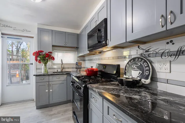a kitchen with stainless steel appliances granite countertop a sink a stove and cabinets