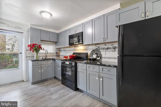 a kitchen with granite countertop a refrigerator stove top oven and sink