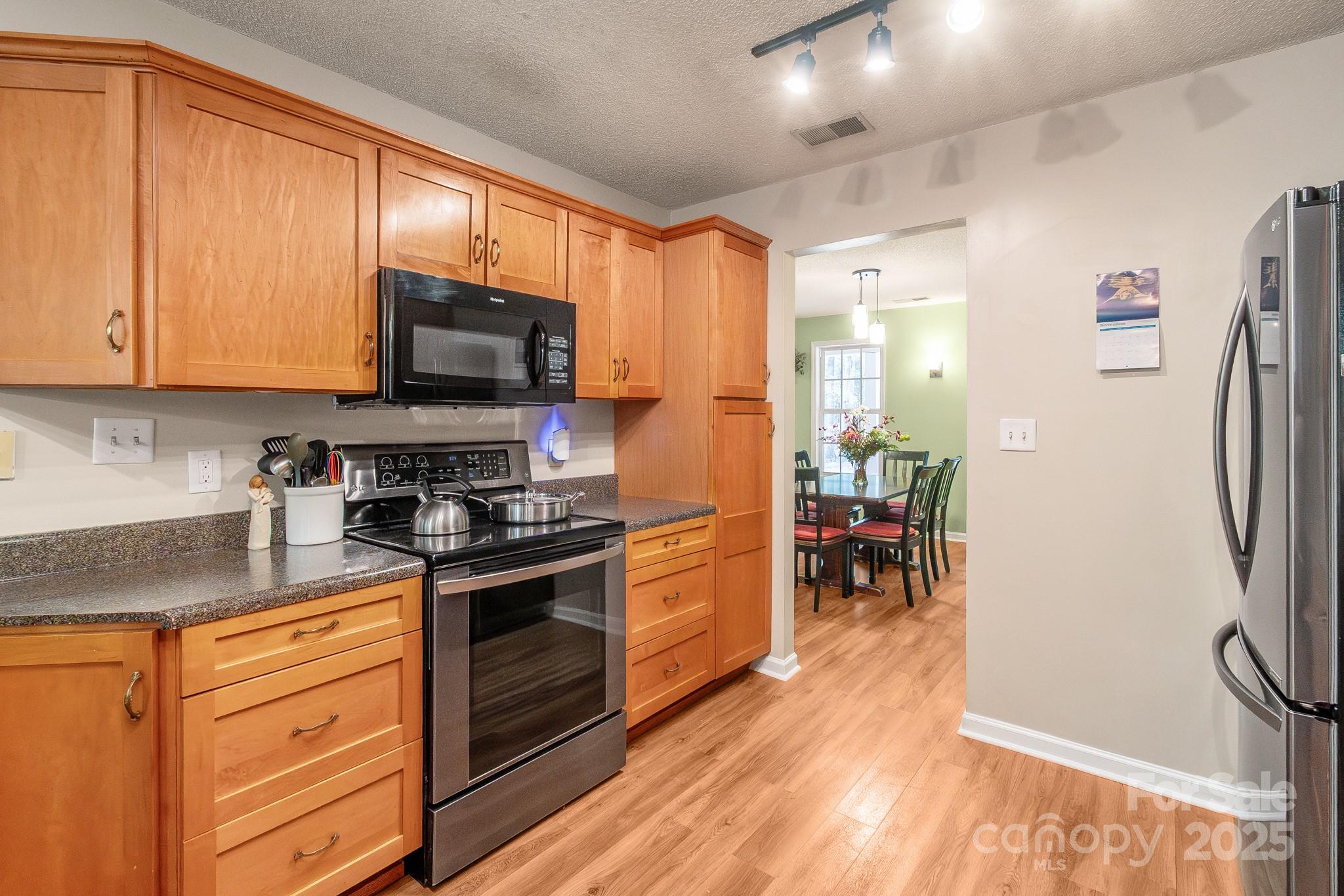 443 State Rd S-28-101 Elgin, SC 29045 - Photo 8 of 45 a kitchen with stainless steel appliances granite countertop a stove top oven a refrigerator and a sink with granite countertops