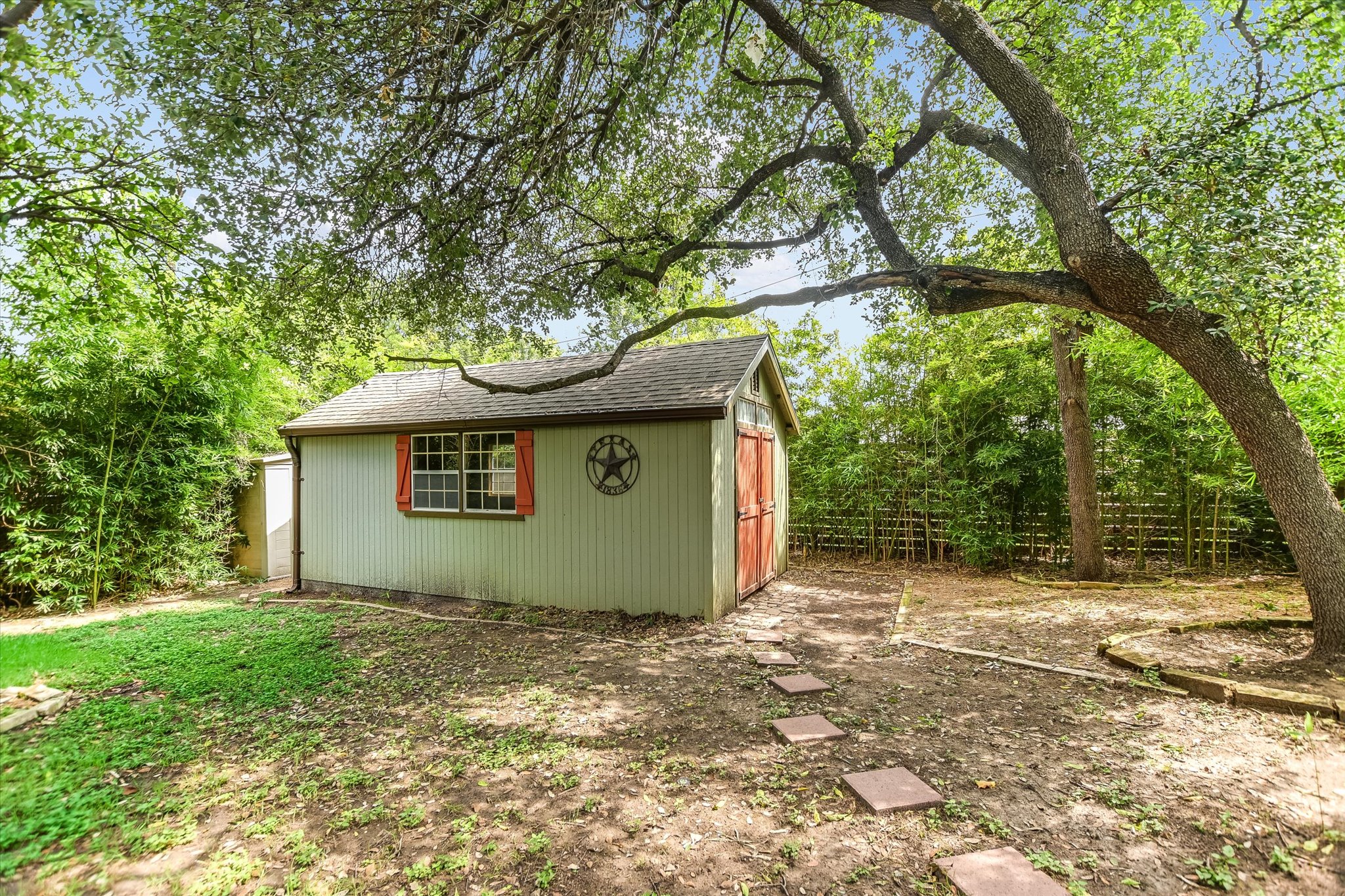 208 Braeswood Road Austin, TX 78704 - Photo 18 of 20 A quaint storage shed with a rustic star emblem offers practical outdoor utility and charm.