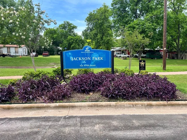 a sign that is sitting in front of a garden
