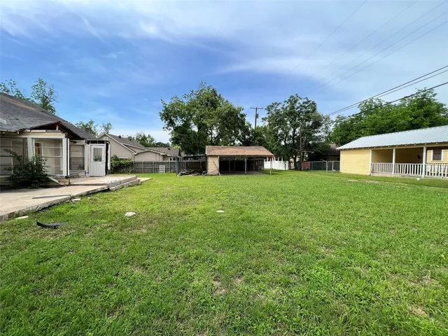 a front view of house with yard and trees in the background