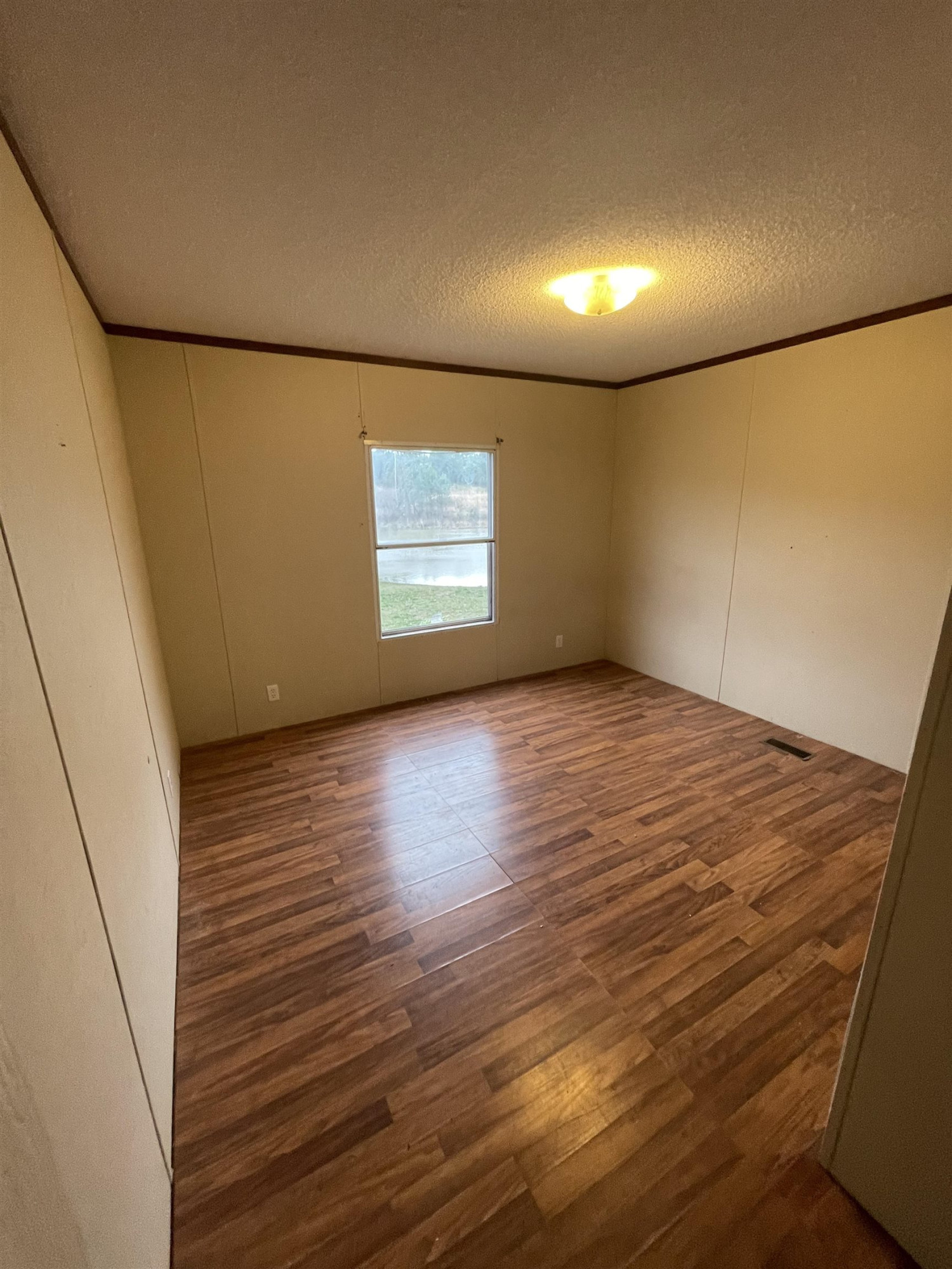 47 Wilkins Road Huron, TN 38345 - Photo 20 of 29 an empty room with wooden floor and windows
