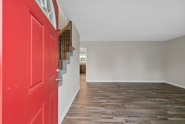 a view of a hallway with wooden floor and staircase