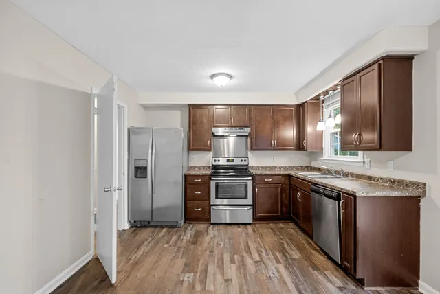 a kitchen with stainless steel appliances granite countertop a stove and a sink