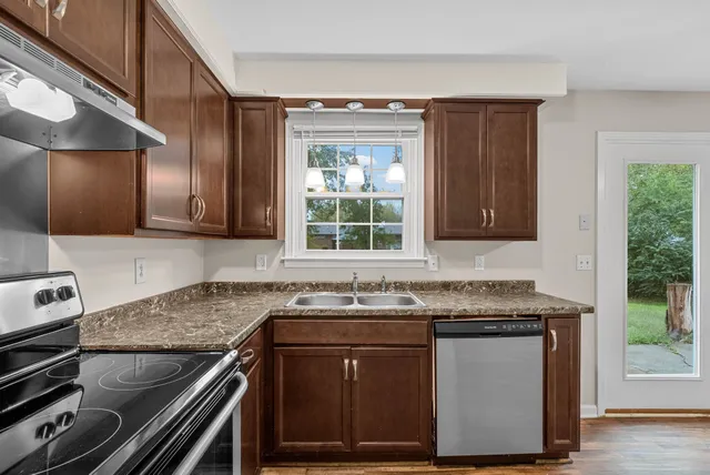 a kitchen with granite countertop a sink and a stove
