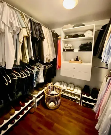 a bedroom with a bed flowerpot and wooden floor