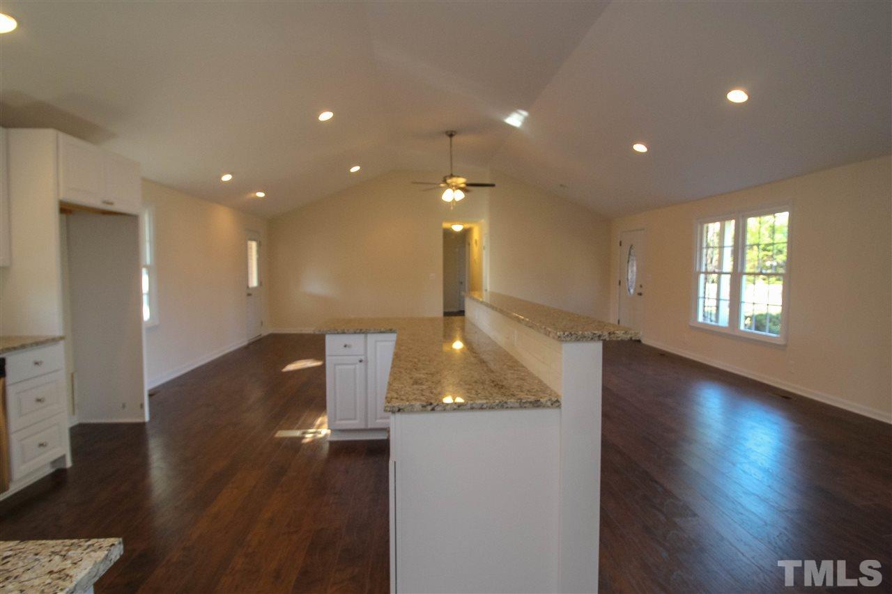 6024 Stancil Farm Road Raleigh, NC 27603 - Photo 4 of 23 a view of an empty room with wooden floor and a window