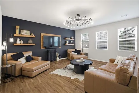 a living room with furniture a chandelier and a flat screen tv