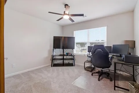 a view of a workspace with furniture and a window