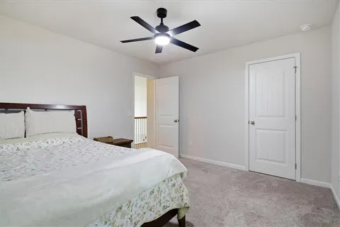 a bedroom with a bed and a ceiling fan