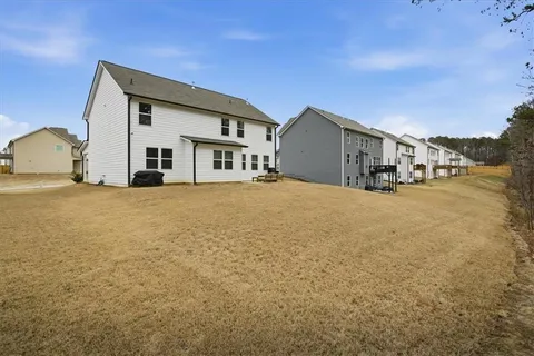 a view of a house with a big yard and large trees