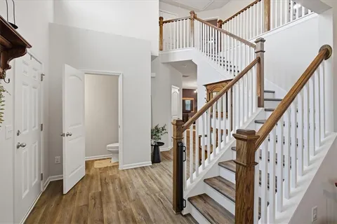 a view of staircase with wooden floor and white walls