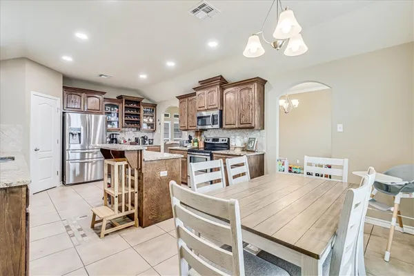 a kitchen with stainless steel appliances kitchen island granite countertop a refrigerator and microwave