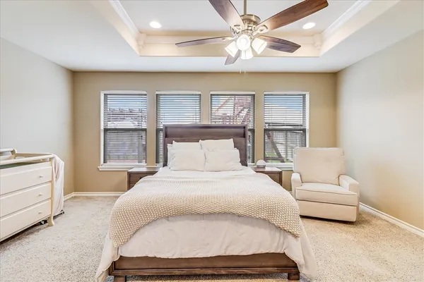 a bedroom with a large bed and a chandelier