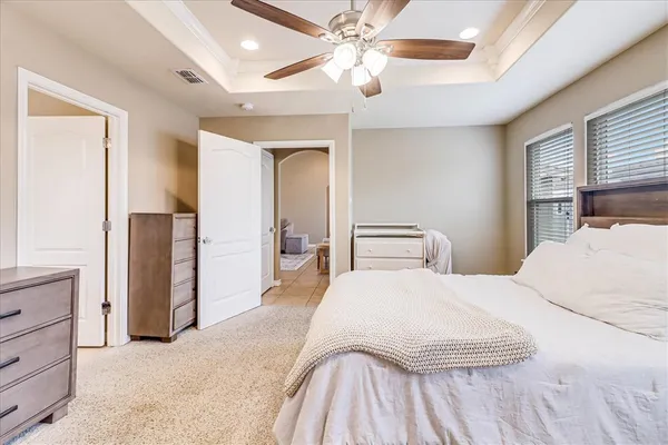 a bedroom with a large bed and a chandelier