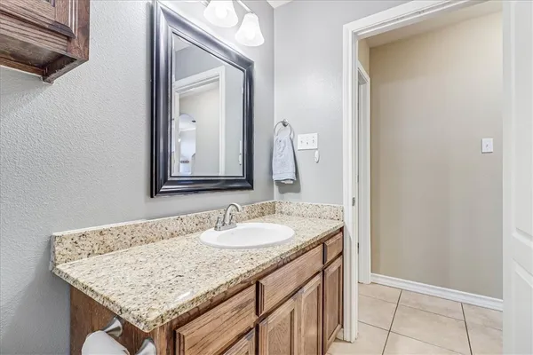 a bathroom with a granite countertop sink and a mirror