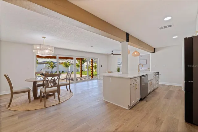 a kitchen with stainless steel appliances wooden floors and white walls