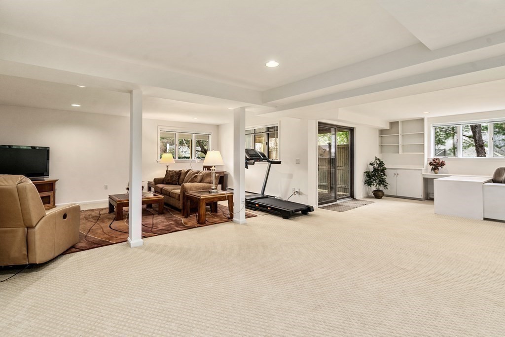1 Pickwick Way, Unit 1 Wayland, MA 01778 - Photo 23 of 32 a living room with furniture a large window and gym equipment