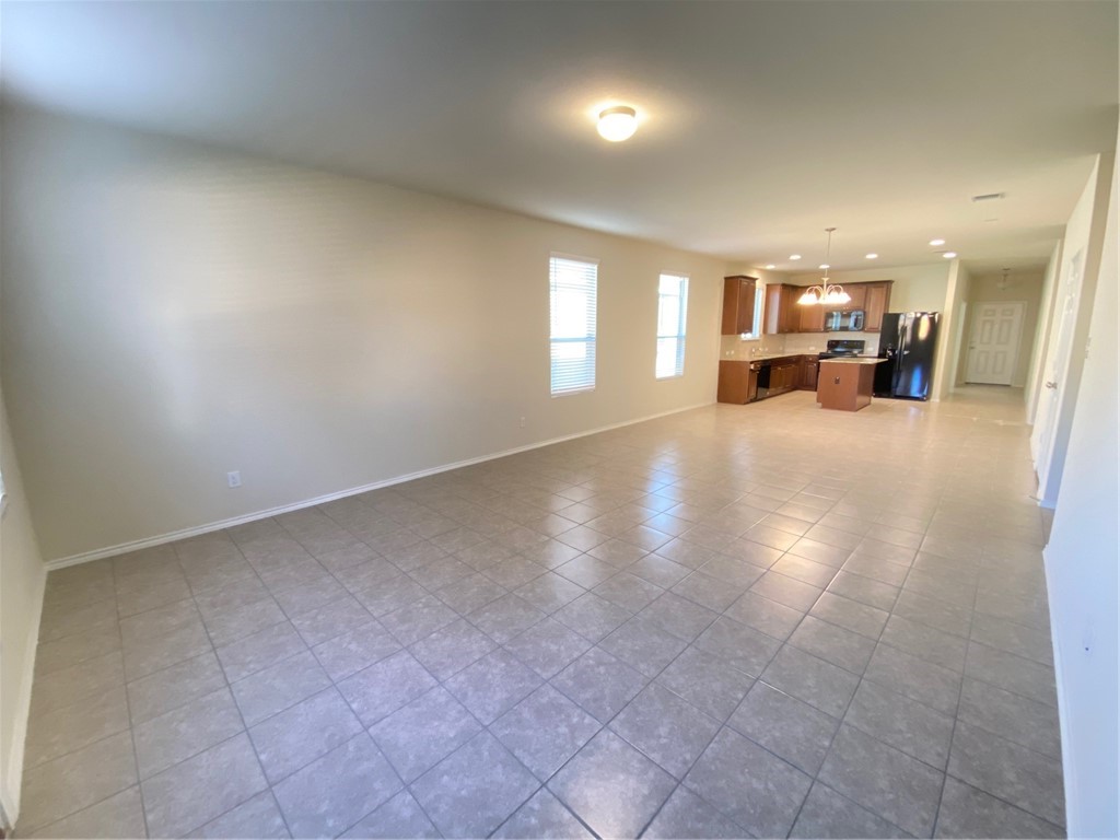 200 Kildeer Pass Jarrell, TX 76537 - Photo 13 of 27 an empty room with a kitchen view and a window