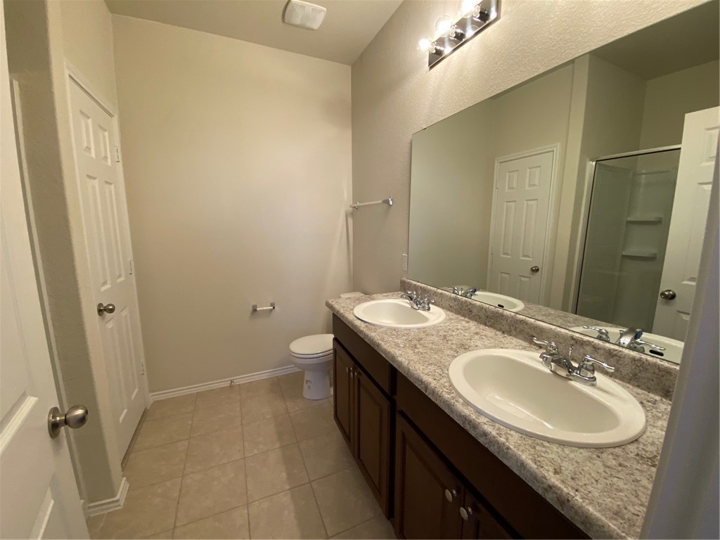 200 Kildeer Pass Jarrell, TX 76537 - Photo 18 of 27 a bathroom with a granite countertop sink a mirror and a toilet