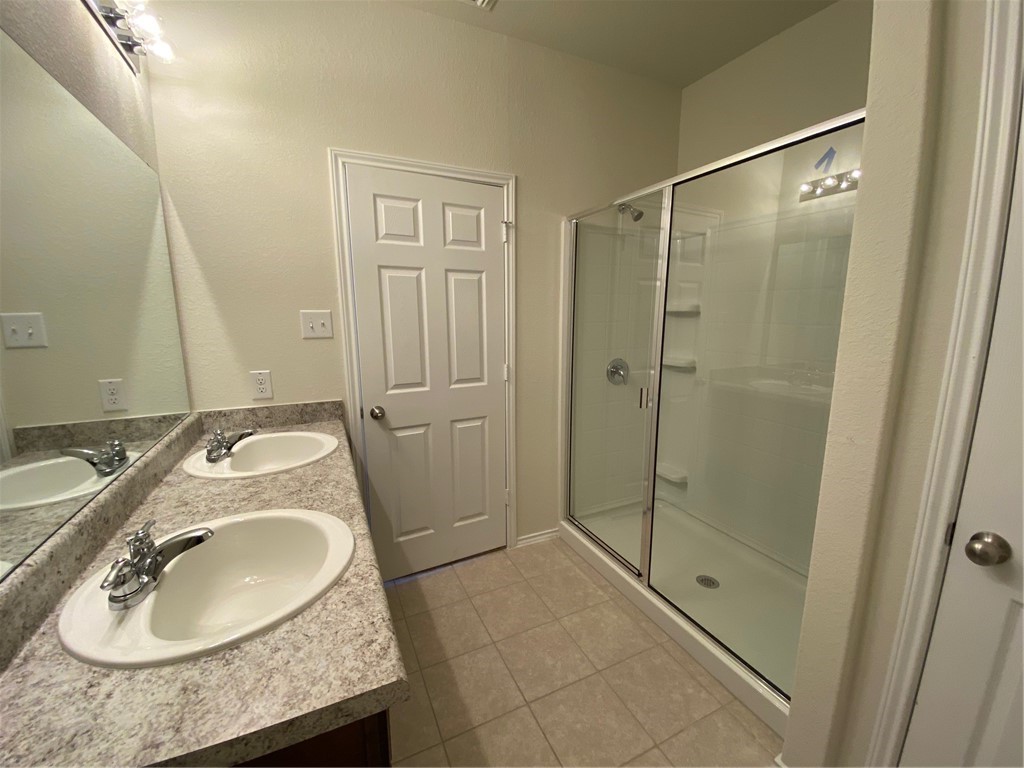 200 Kildeer Pass Jarrell, TX 76537 - Photo 19 of 27 a bathroom with a granite countertop sink a mirror and shower