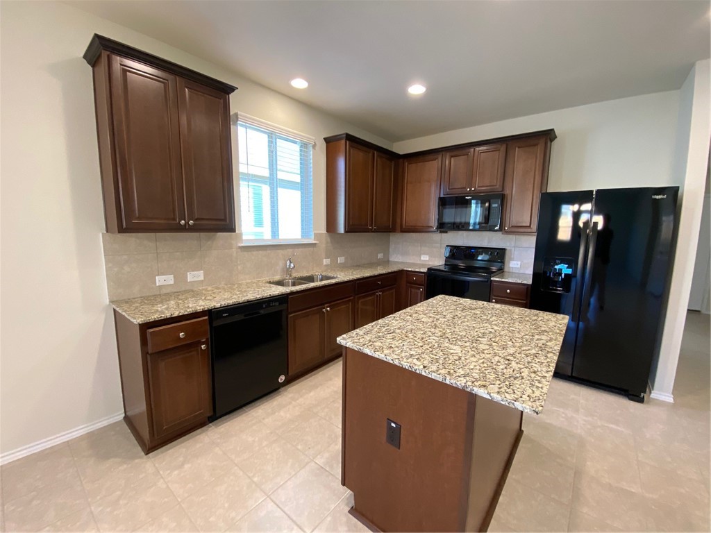 200 Kildeer Pass Jarrell, TX 76537 - Photo 6 of 27 a kitchen with stainless steel appliances granite countertop a refrigerator a sink a stove a microwave and island