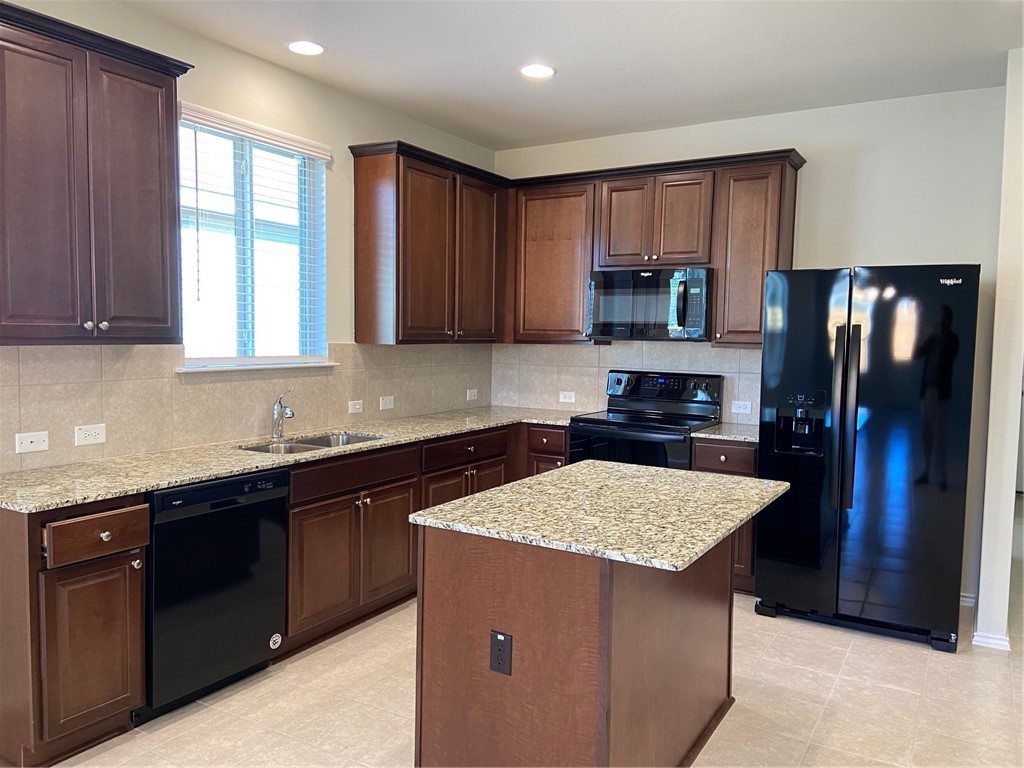 200 Kildeer Pass Jarrell, TX 76537 - Photo 7 of 27 a kitchen with a refrigerator sink and wooden cabinets