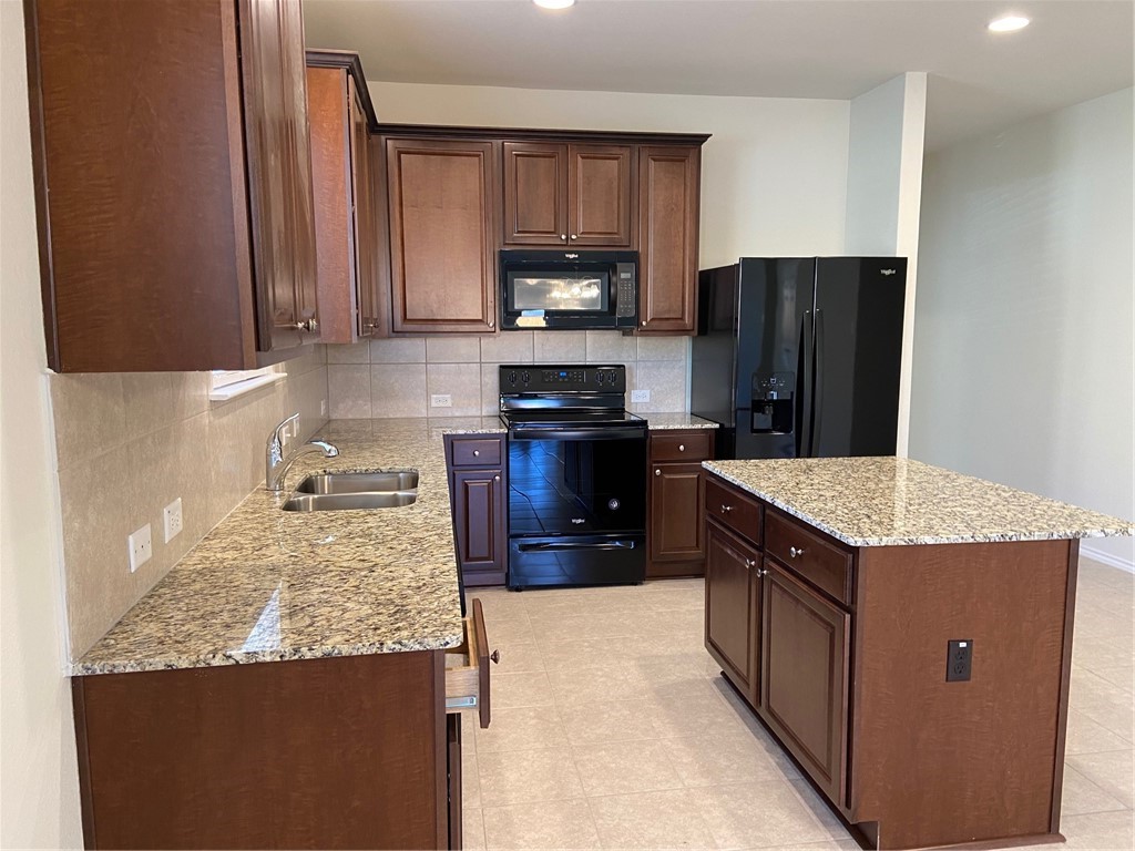 200 Kildeer Pass Jarrell, TX 76537 - Photo 8 of 27 a kitchen with stainless steel appliances granite countertop a stove a refrigerator and a sink