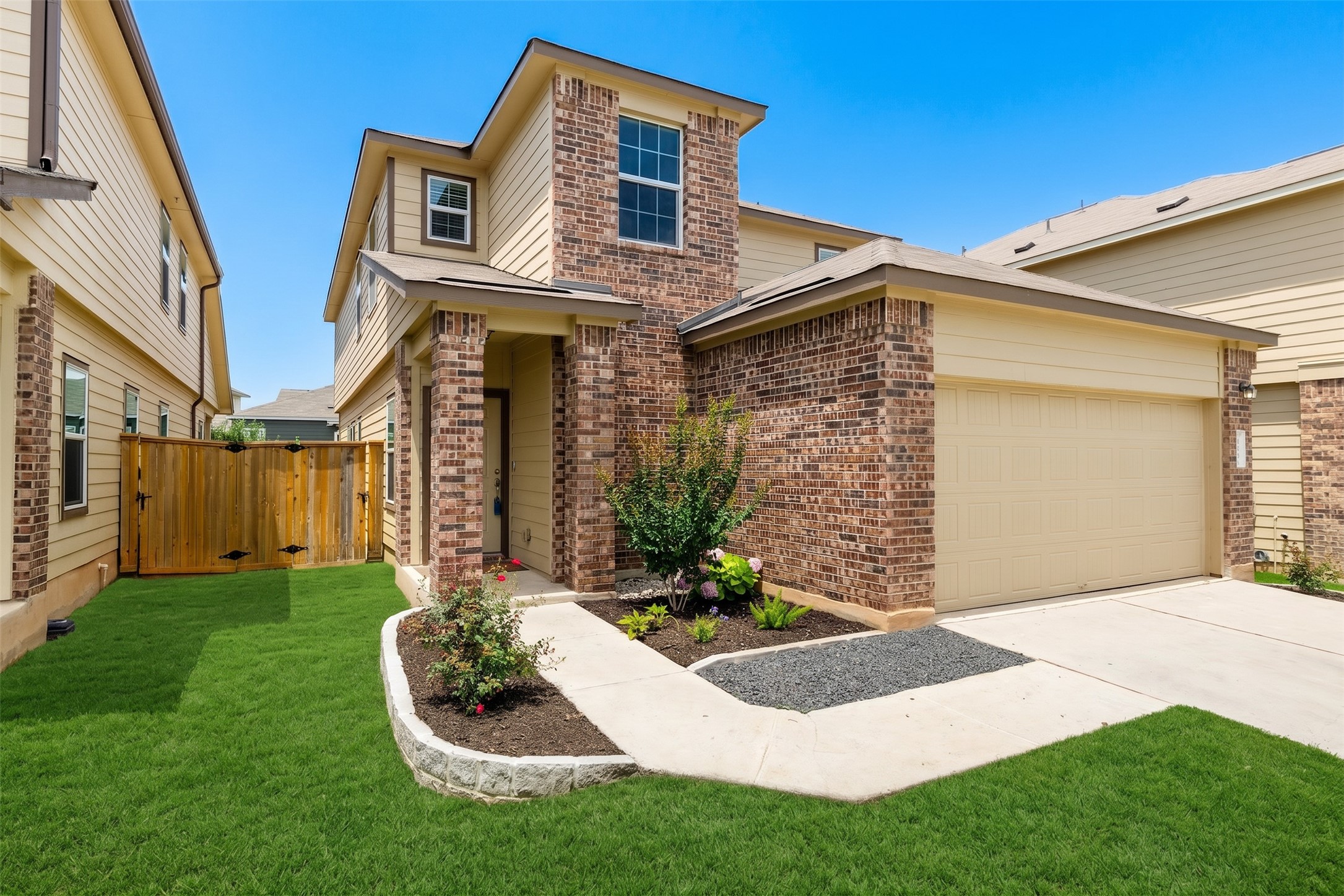 425 Perfect World Loop Jarrell, TX 76537 - Photo 1 of 29 Two-story residential exterior featuring a brick and siding facade, an attached garage, and a concrete driveway