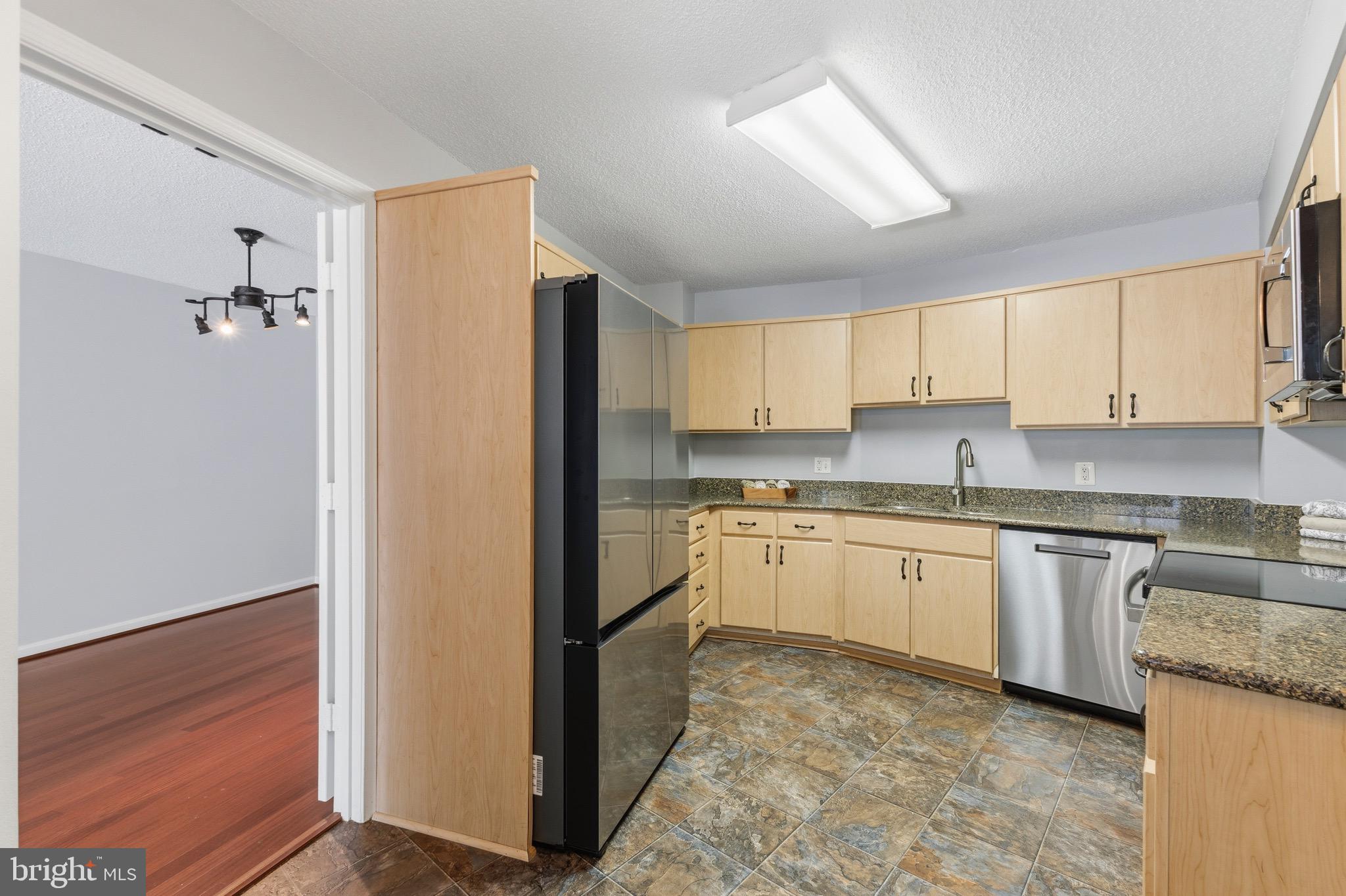 14801 Pennfield Circle, Unit 206 Silver Spring, MD 20906 - Photo 11 of 37 a kitchen with granite countertop a refrigerator sink and cabinets