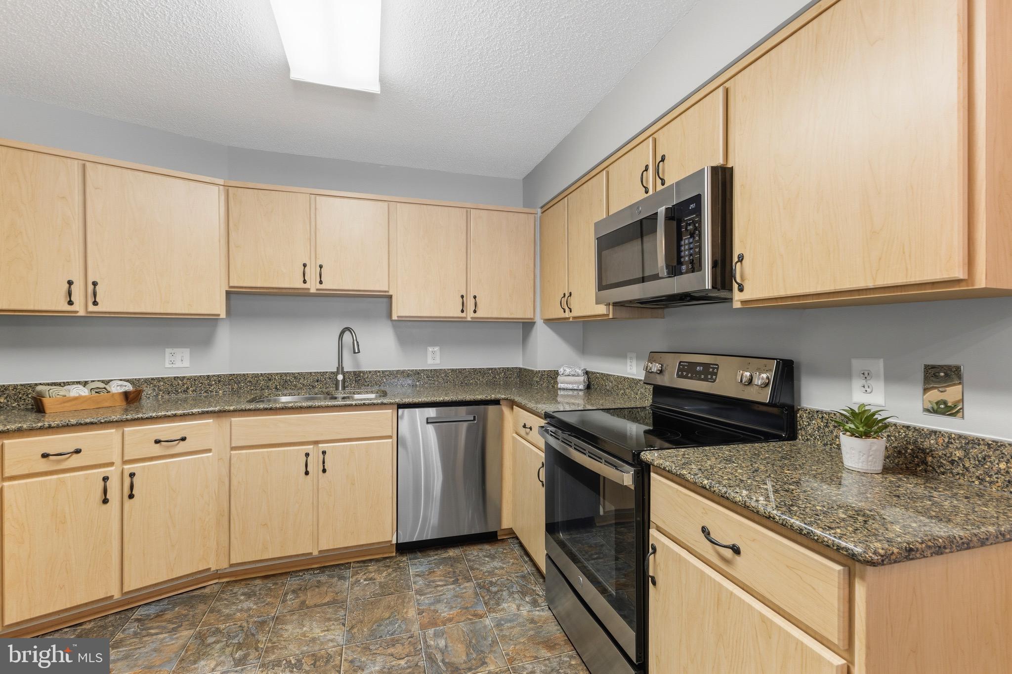 14801 Pennfield Circle, Unit 206 Silver Spring, MD 20906 - Photo 12 of 37 a kitchen with granite countertop cabinets stainless steel appliances and a sink