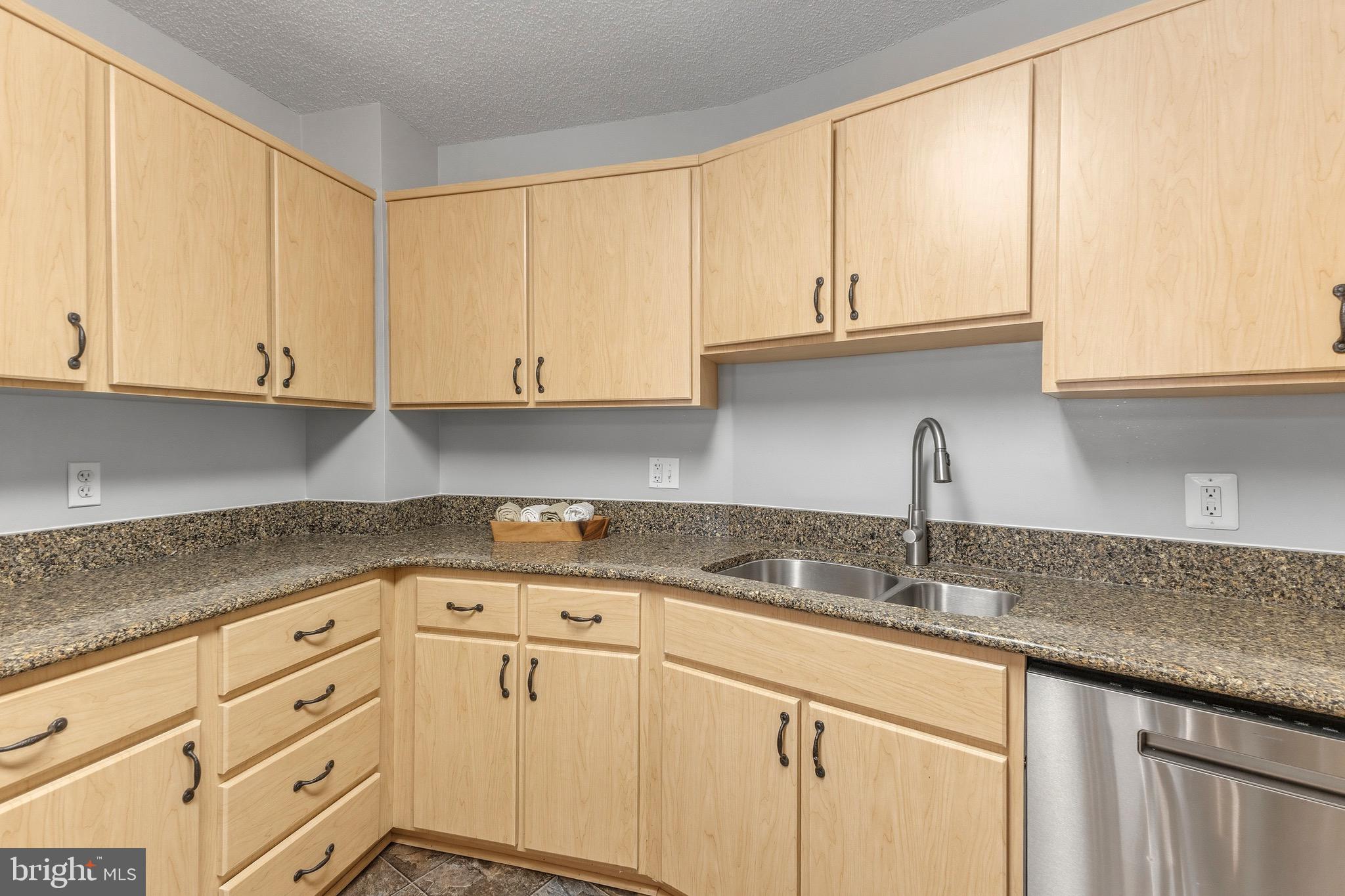 14801 Pennfield Circle, Unit 206 Silver Spring, MD 20906 - Photo 13 of 37 a kitchen with granite countertop white cabinets and a sink