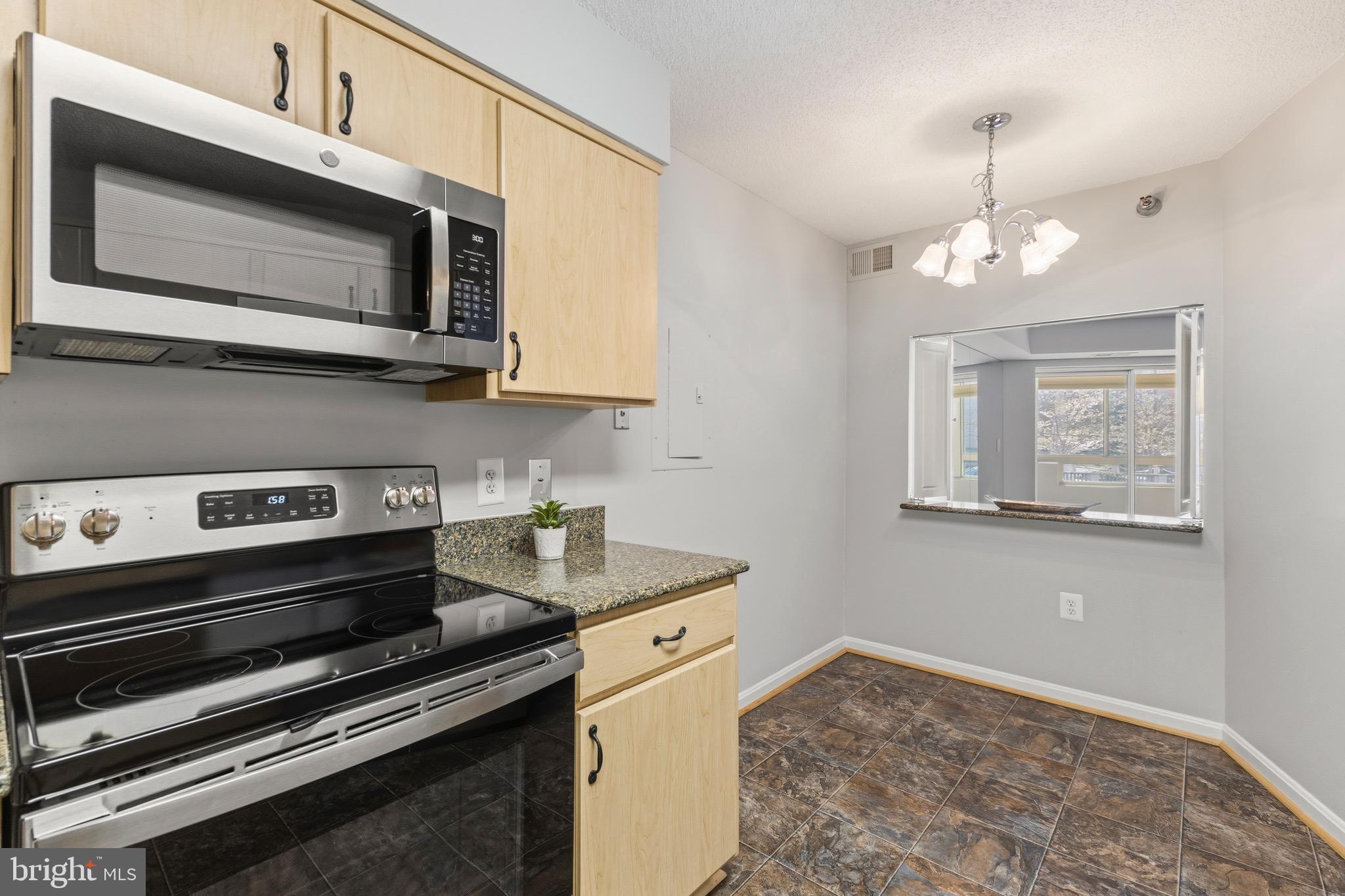 14801 Pennfield Circle, Unit 206 Silver Spring, MD 20906 - Photo 14 of 37 a kitchen with stainless steel appliances granite countertop a stove and a microwave