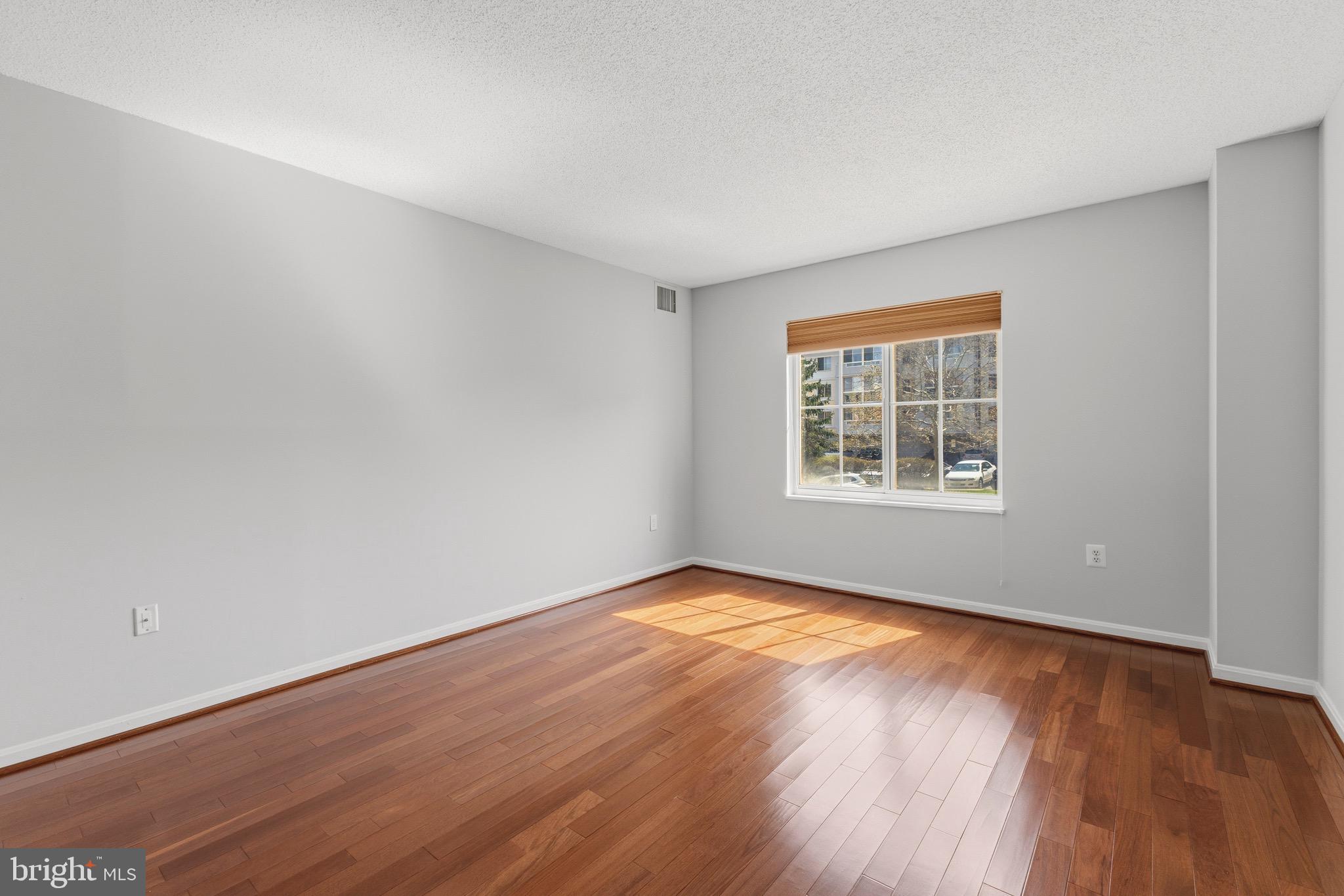 14801 Pennfield Circle, Unit 206 Silver Spring, MD 20906 - Photo 16 of 37 an empty room with wooden floor and windows