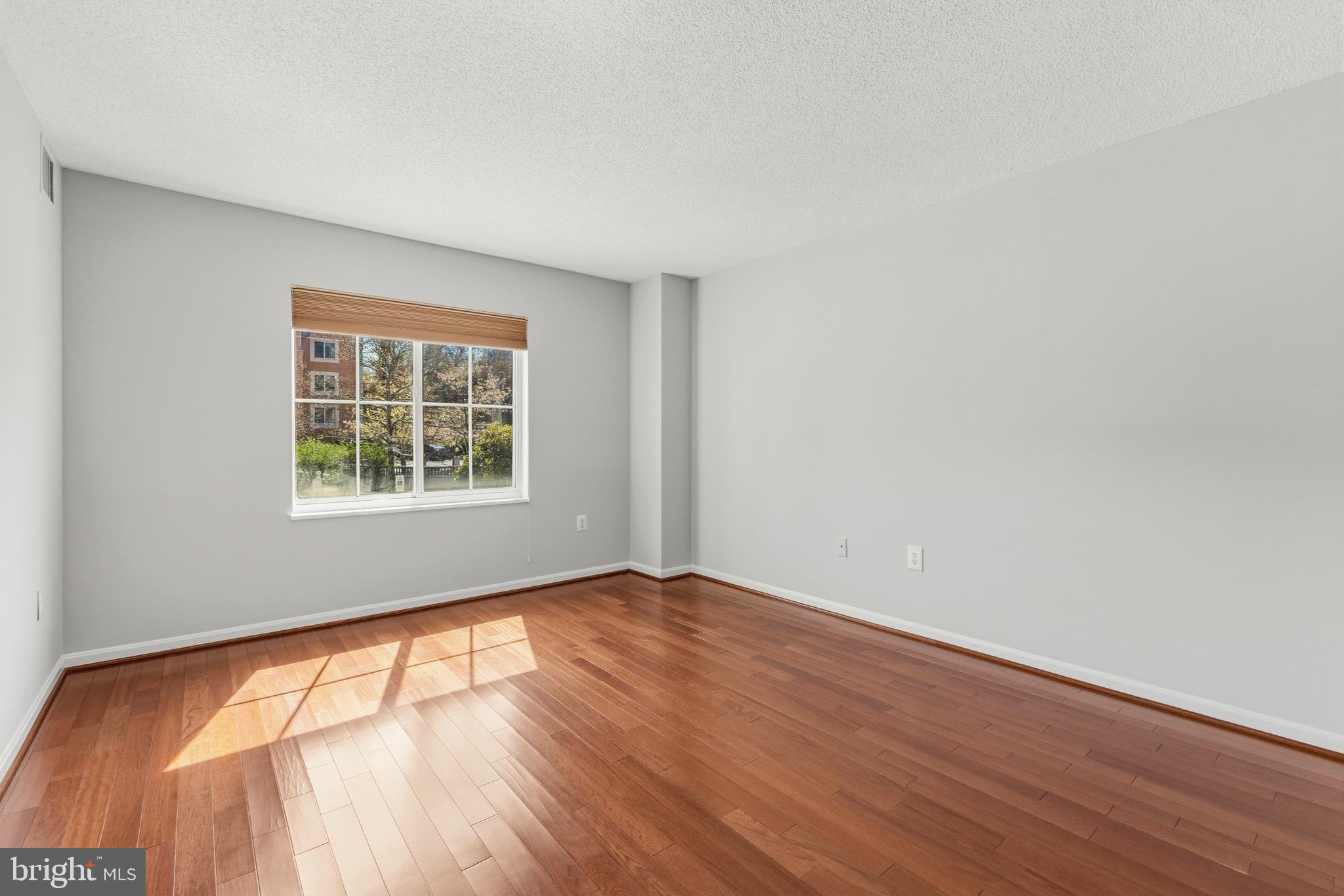 14801 Pennfield Circle, Unit 206 Silver Spring, MD 20906 - Photo 20 of 37 an empty room with wooden floor and windows