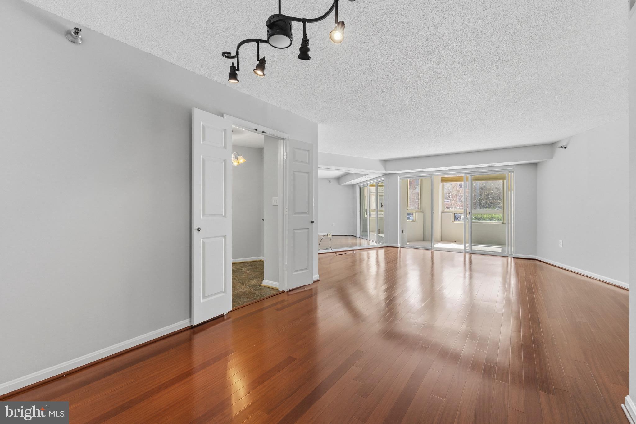14801 Pennfield Circle, Unit 206 Silver Spring, MD 20906 - Photo 2 of 37 a view of an empty room with wooden floor and windows
