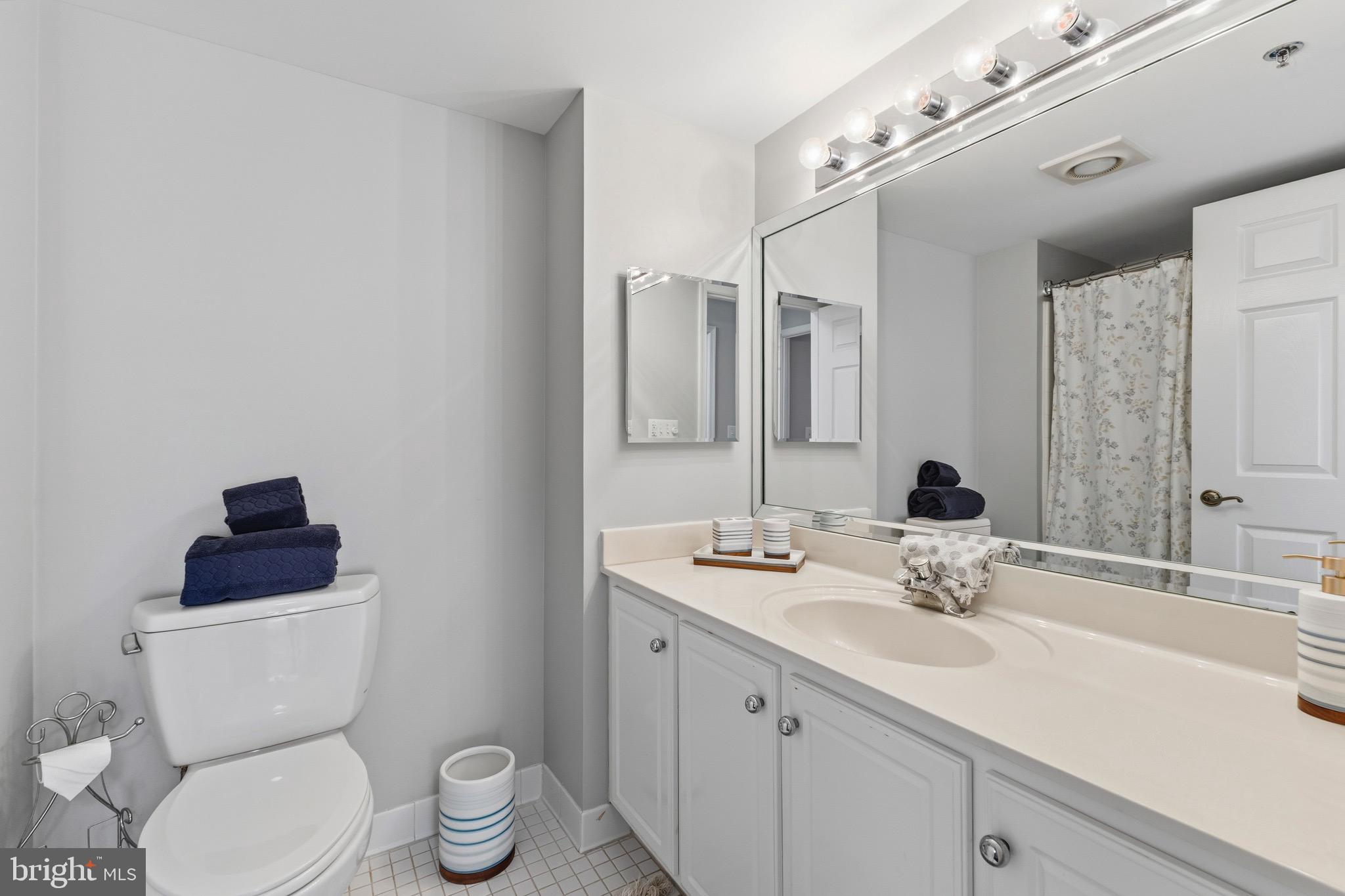 14801 Pennfield Circle, Unit 206 Silver Spring, MD 20906 - Photo 24 of 37 a bathroom with a toilet a sink and mirror