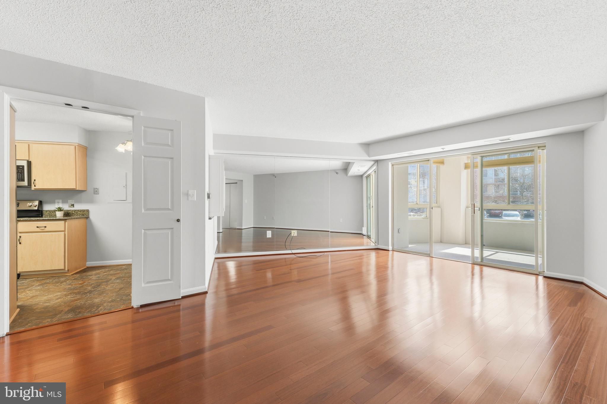 14801 Pennfield Circle, Unit 206 Silver Spring, MD 20906 - Photo 3 of 37 a view of an empty room with wooden floor and a window