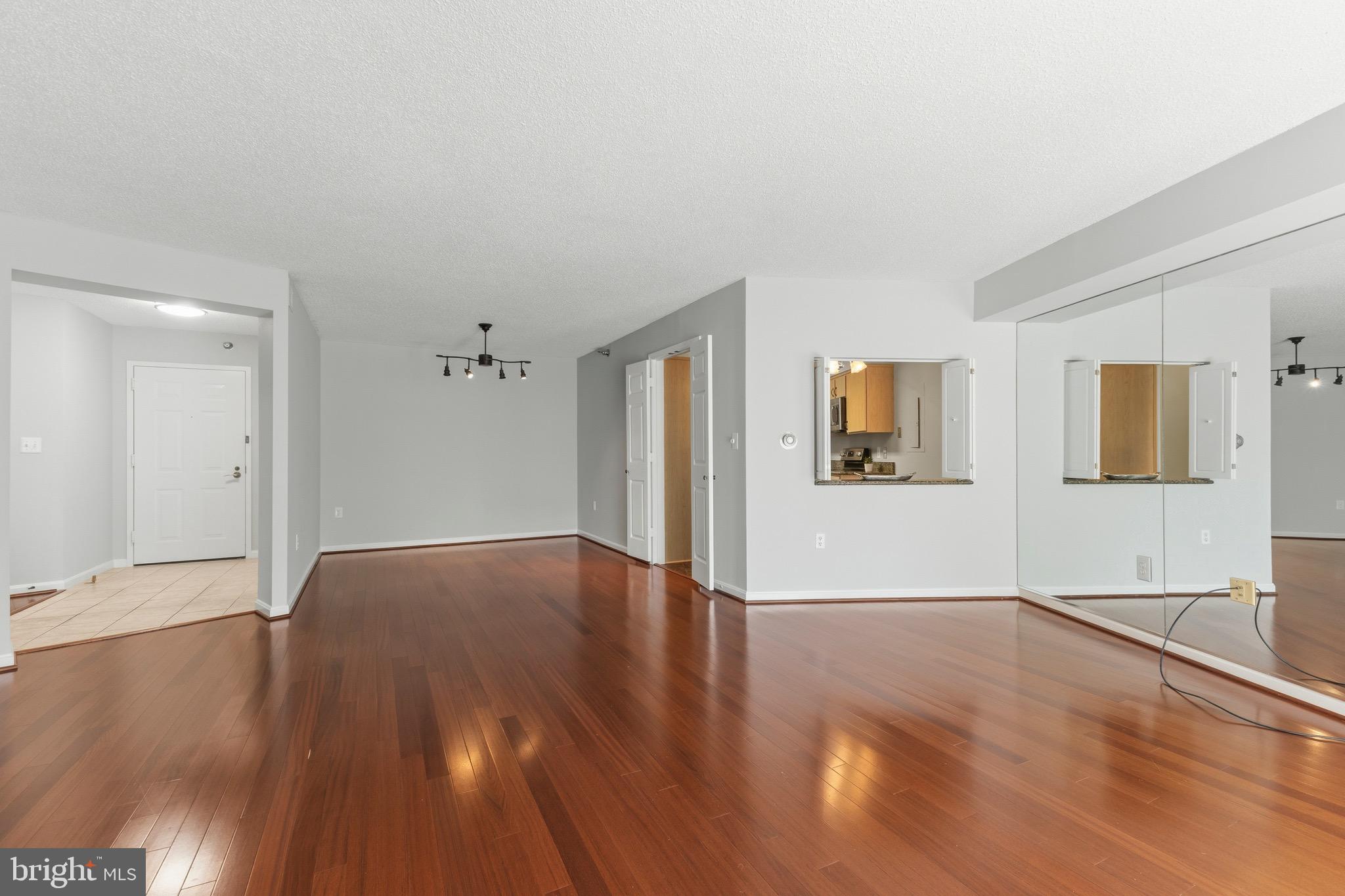 14801 Pennfield Circle, Unit 206 Silver Spring, MD 20906 - Photo 6 of 37 a view of an empty room with wooden floor and a window