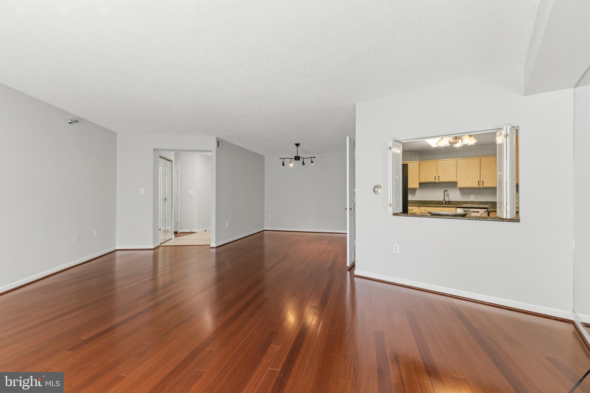 14801 Pennfield Circle, Unit 206 Silver Spring, MD 20906 - Photo 7 of 37 an empty room with wooden floor and windows