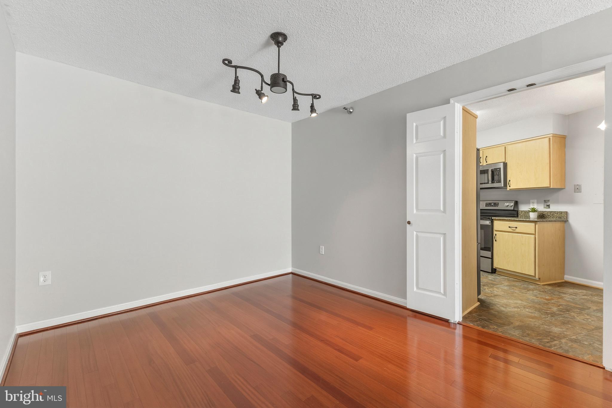 14801 Pennfield Circle, Unit 206 Silver Spring, MD 20906 - Photo 10 of 37 a view of a kitchen with a fridge and wooden floor