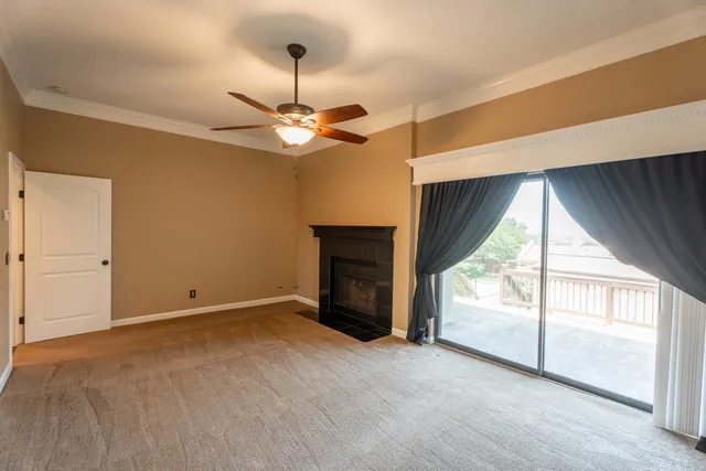 a view of an empty room with a fireplace and a window
