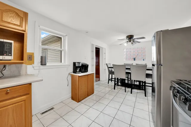 a kitchen with stainless steel appliances kitchen island granite countertop a refrigerator and a stove top oven