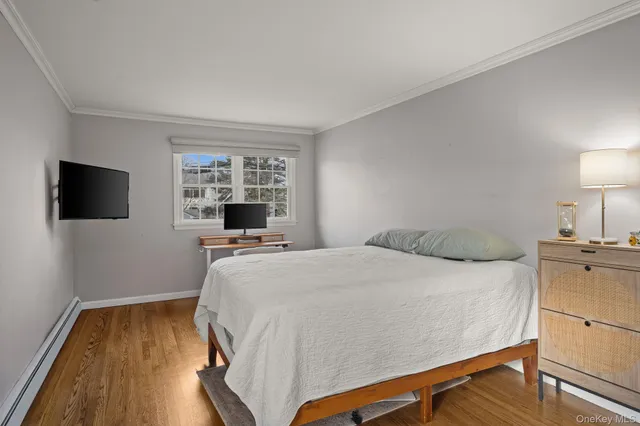 a bedroom with a bed and a flat tv screen on dresser