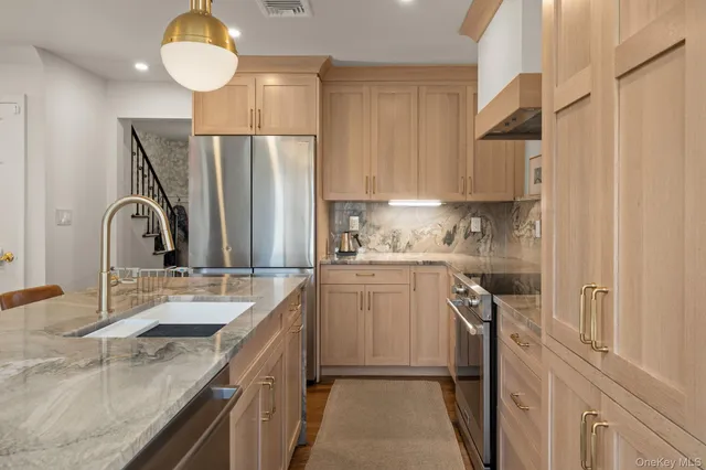 a kitchen with a sink a refrigerator and cabinets