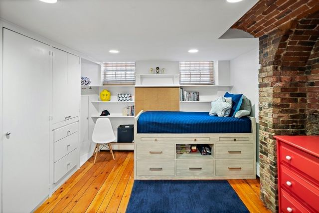 a kitchen with stainless steel appliances kitchen island wooden floors and white walls